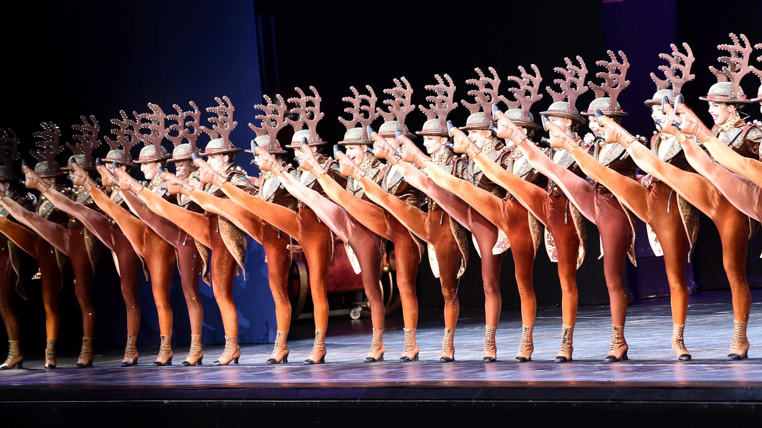 The Radio City Rockettes выступают на сцене во время рождественского зрелищ...